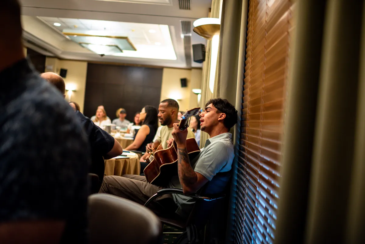 A student playing guitar during a meeting