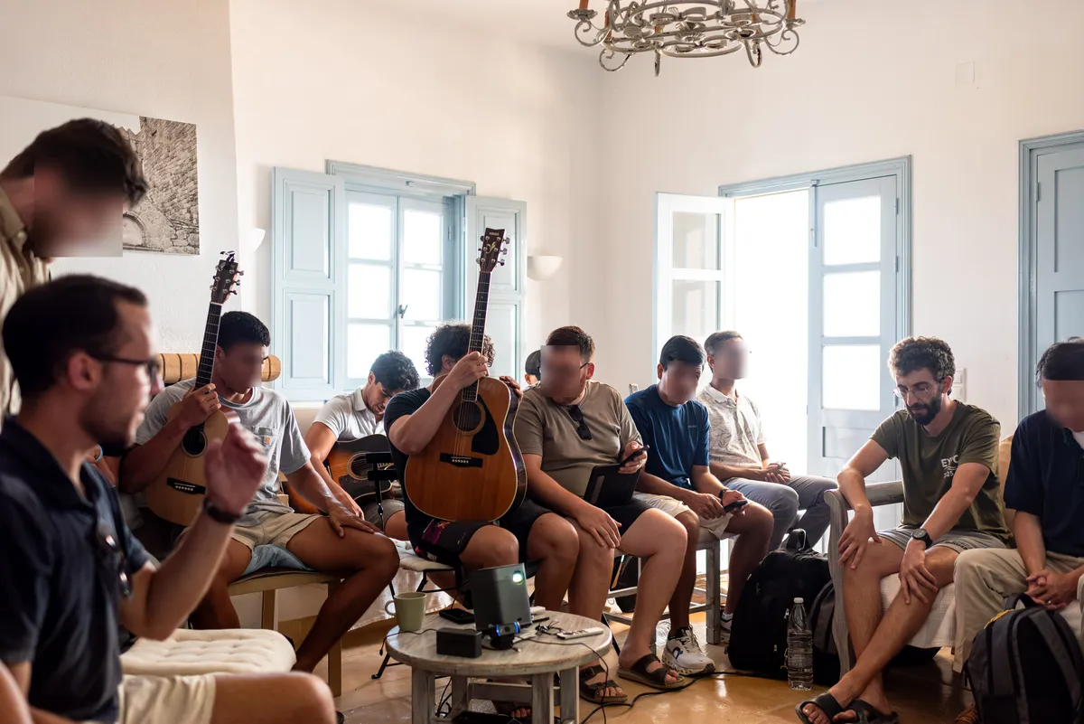 Students with guitars in a bright island room