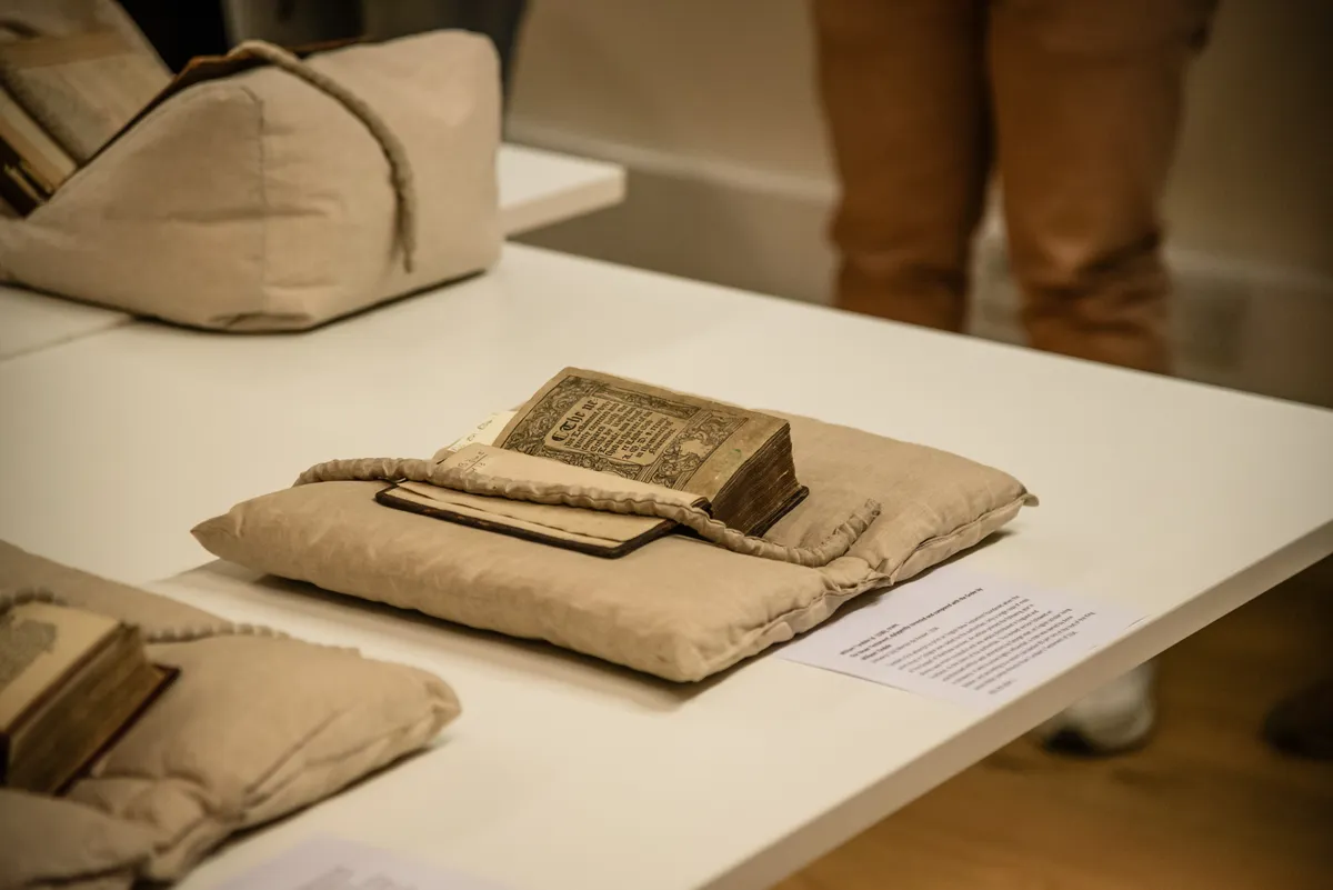 An early printed book open on a cushion in a library display