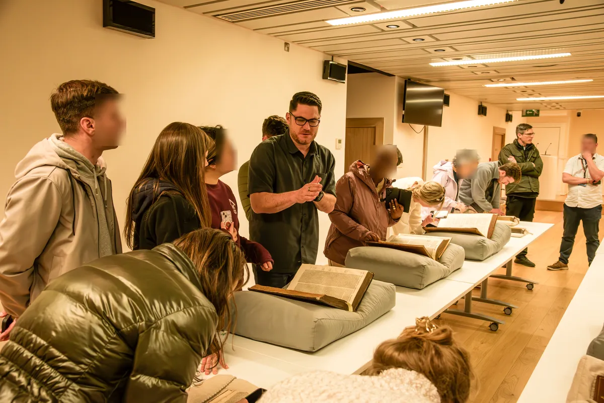 A librarian showing the group early printed Bibles