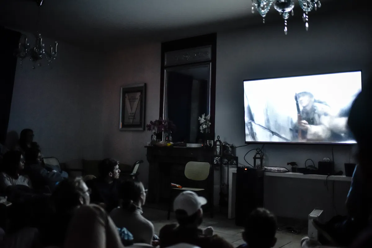 The group watching a film together in a dim living room