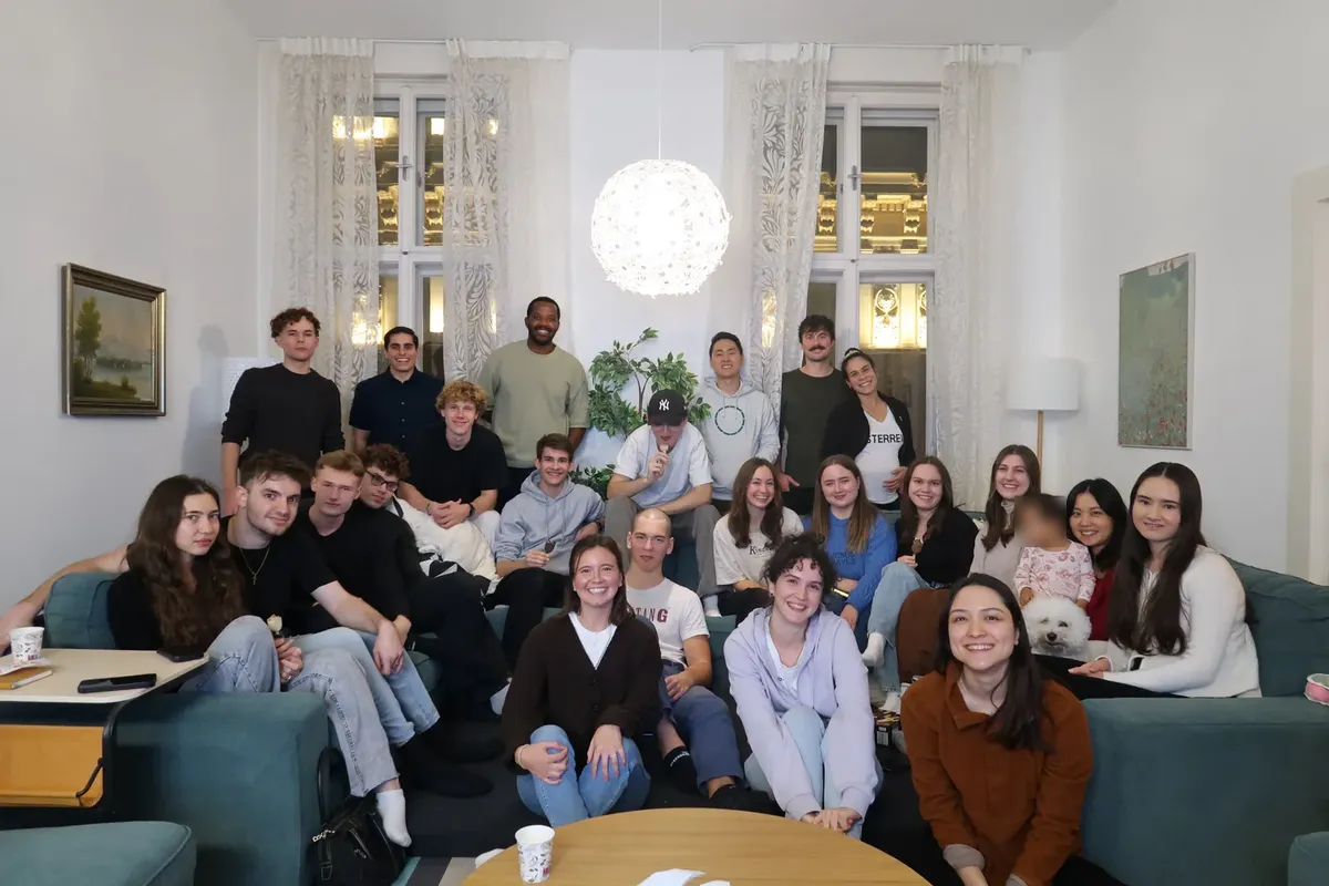 Students filling the sofas and floor of a Viennese living room