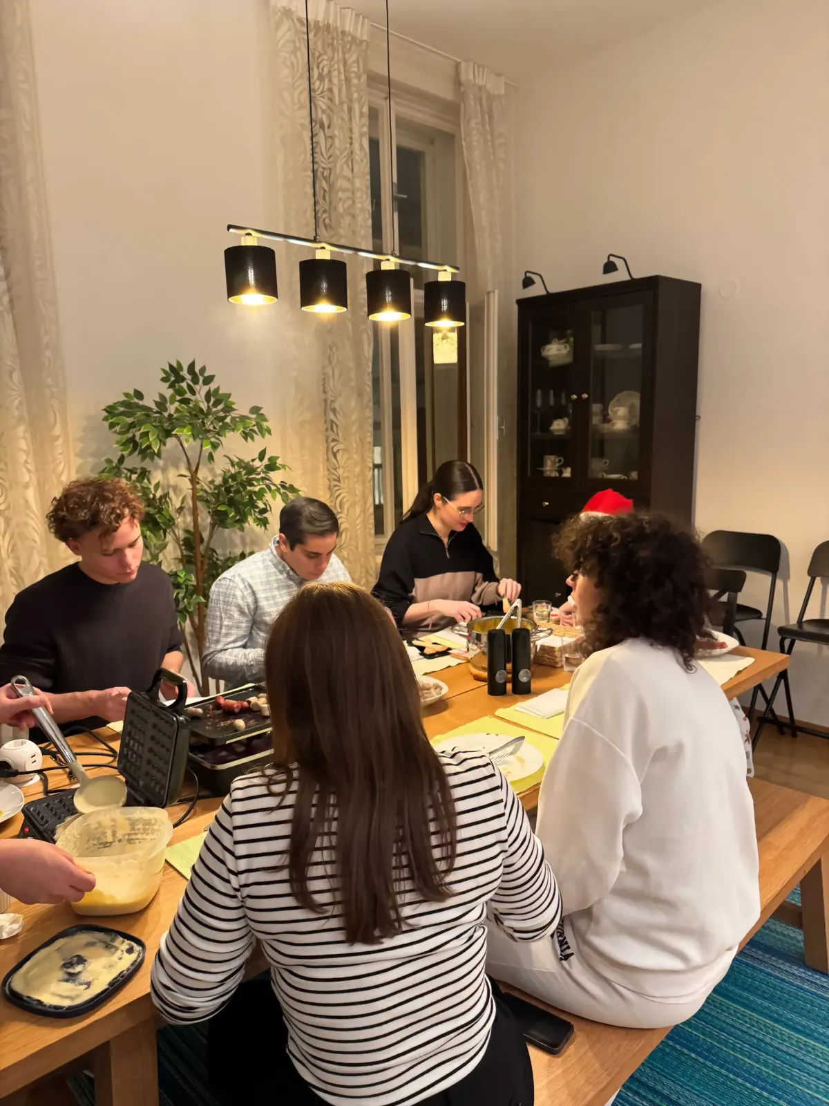 Students sharing a meal around a long table at a CSWien evening