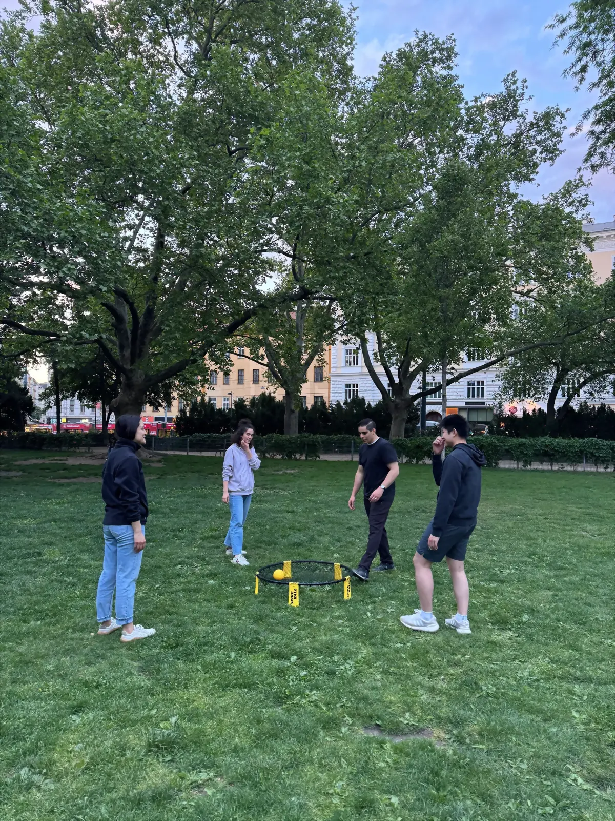 Students playing a lawn game in a park at dusk