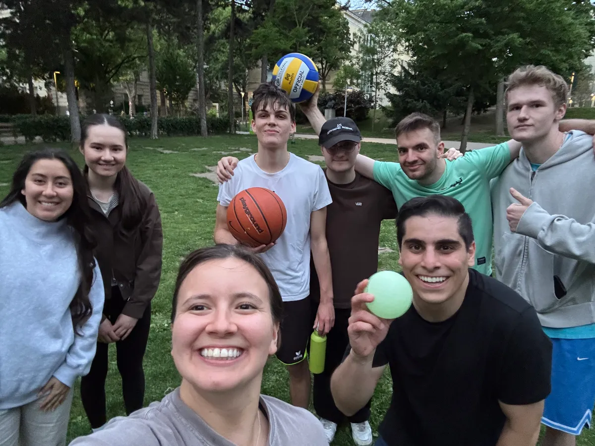 Group selfie on a park lawn with a basketball and a volleyball