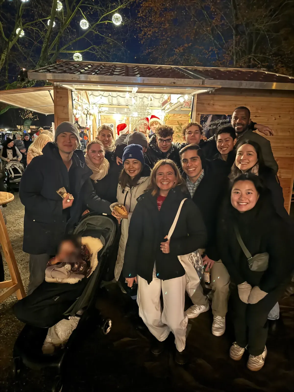 Students at a lit-up Christmas market stall at night
